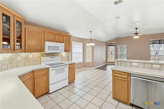 kitchen with light tile patterned floors, white appliances, visible vents, light countertops, and decorative backsplash