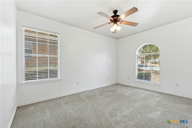 empty room with carpet floors, ceiling fan, and baseboards