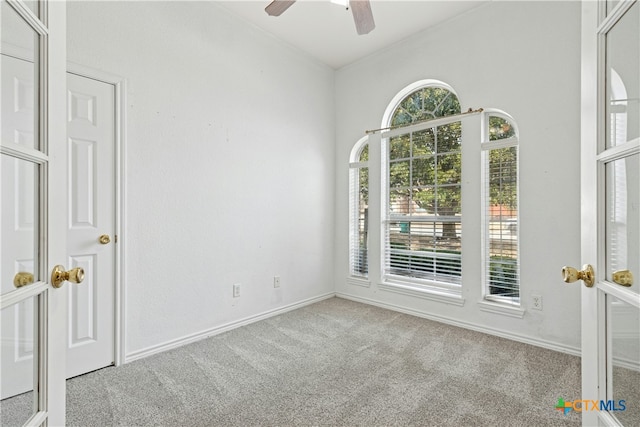 carpeted empty room featuring ceiling fan, baseboards, and vaulted ceiling