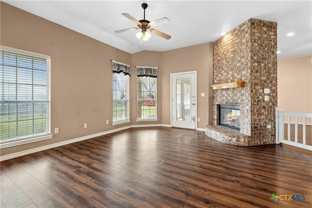 unfurnished living room with a ceiling fan, a fireplace, baseboards, and wood finished floors