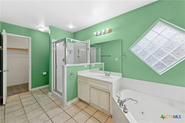 bathroom featuring a tub with jets, a shower stall, vanity, and tile patterned floors