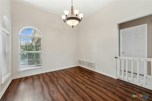 spare room with visible vents, a chandelier, wood finished floors, and ornamental molding