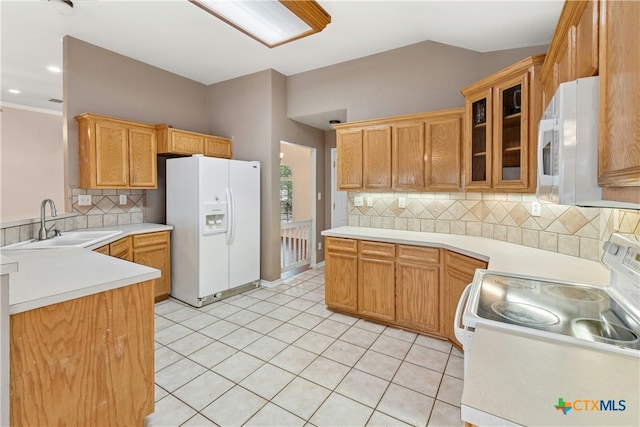 kitchen with white appliances, tasteful backsplash, glass insert cabinets, light countertops, and a sink