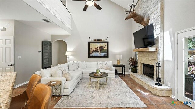 405 Pinnacle Pkwy, New Braunfels, TX 78132 - tiled living room featuring a stone fireplace, ceiling fan, high vaulted ceiling, and arched walkways