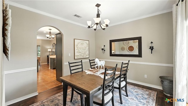 405 Pinnacle Pkwy, New Braunfels, TX 78132 - dining room with a chandelier, arched walkways, crown molding, and dark wood-style flooring