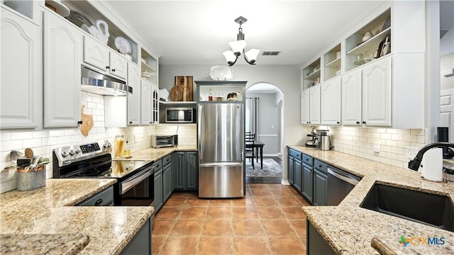 405 Pinnacle Pkwy, New Braunfels, TX 78132 - kitchen with stainless steel appliances, open shelves, arched walkways, white cabinets, and tasteful backsplash