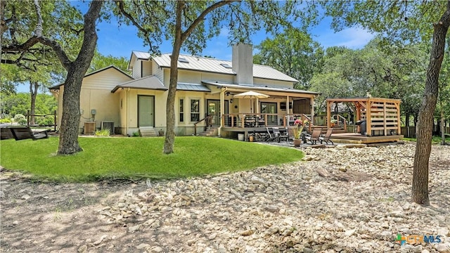 405 Pinnacle Pkwy, New Braunfels, TX 78132 - back of property featuring a wooden deck, a chimney, a yard, and a metal roof