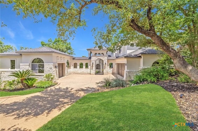 124 Schooner Dr, Lakeway, TX 78738 - mediterranean / spanish-style home with an attached garage, stone siding, concrete driveway, stucco siding, and a front lawn