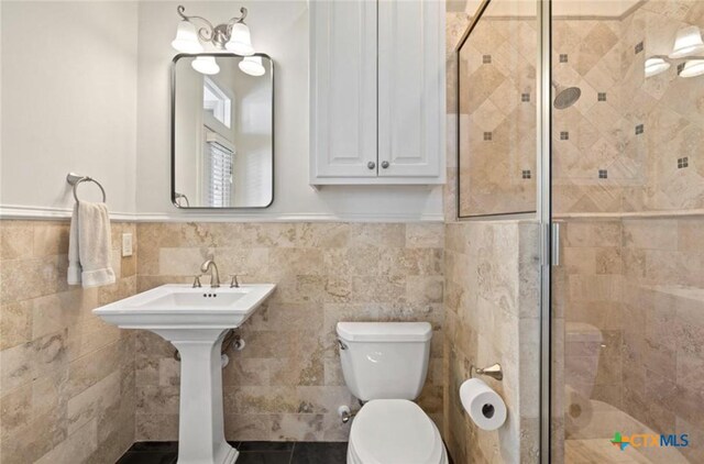 124 Schooner Dr, Lakeway, TX 78738 - full bathroom with a stall shower, wainscoting, and tile walls