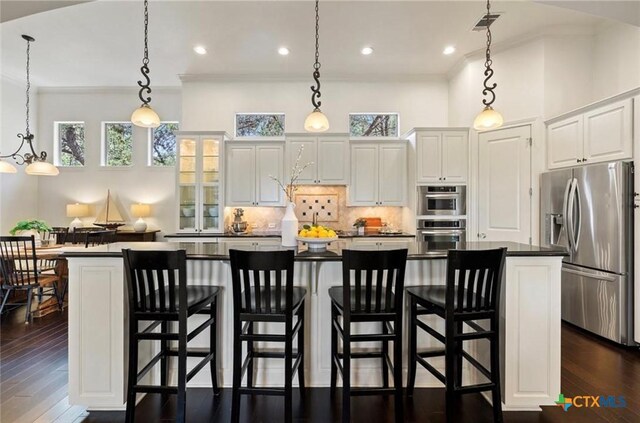 124 Schooner Dr, Lakeway, TX 78738 - kitchen featuring stainless steel fridge, crown molding, dark countertops, a spacious island, and white cabinetry