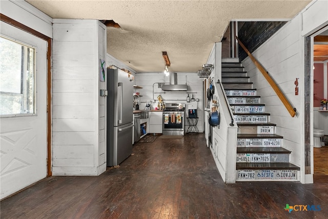 interior space featuring wood-type flooring, wooden walls, and a textured ceiling