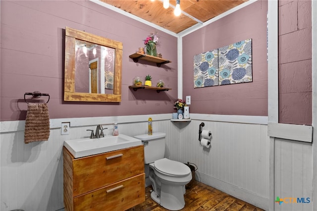 bathroom featuring wood-type flooring, vanity, wooden walls, toilet, and wooden ceiling