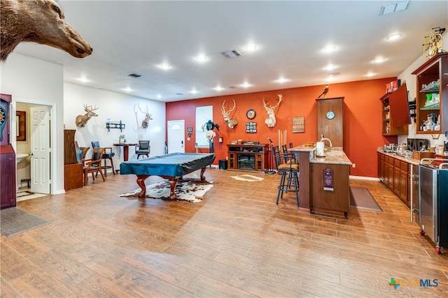 rec room with bar area, pool table, and light hardwood / wood-style floors