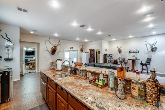 kitchen featuring dark hardwood / wood-style floors, sink, and light stone countertops