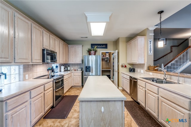 kitchen featuring sink, appliances with stainless steel finishes, tasteful backsplash, hanging light fixtures, and a center island