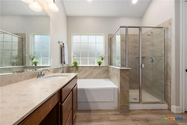 bathroom with a stall shower, wood finished floors, and vanity