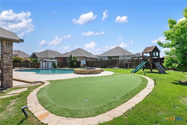 view of pool featuring a lawn, a fenced backyard, a shed, and an outdoor structure