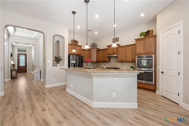 kitchen featuring brown cabinetry, light wood finished floors, and stainless steel appliances