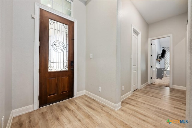 entrance foyer with baseboards and light wood finished floors
