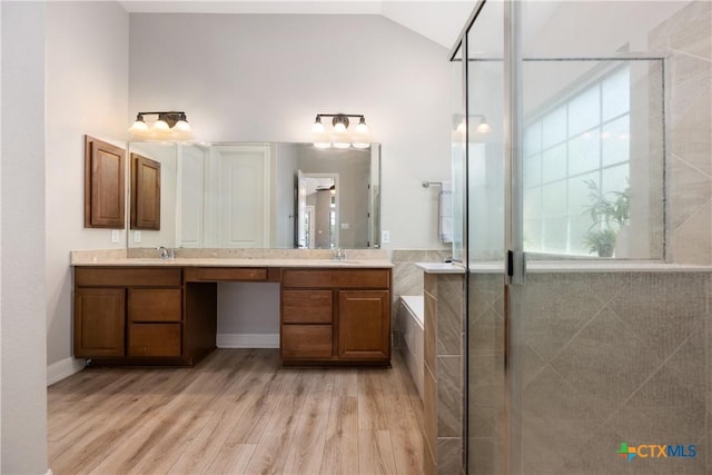 full bath featuring wood finished floors, a tile shower, a bath, vanity, and lofted ceiling