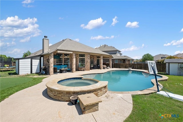 view of swimming pool with a patio, a shed, an outbuilding, a fenced backyard, and a pool with connected hot tub