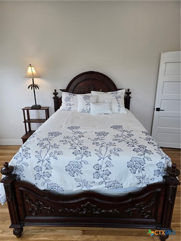 bedroom featuring baseboards and wood finished floors