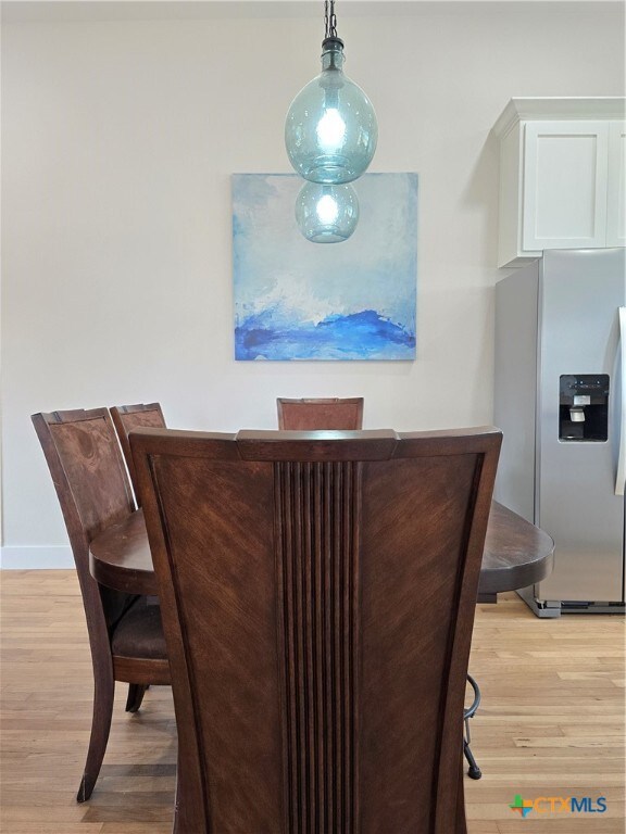 dining room featuring light wood-type flooring and baseboards