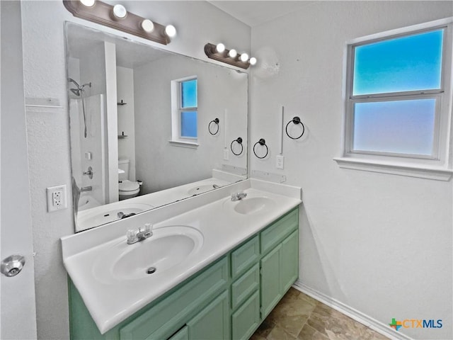 full bath featuring double vanity, toilet, baseboards, and a sink