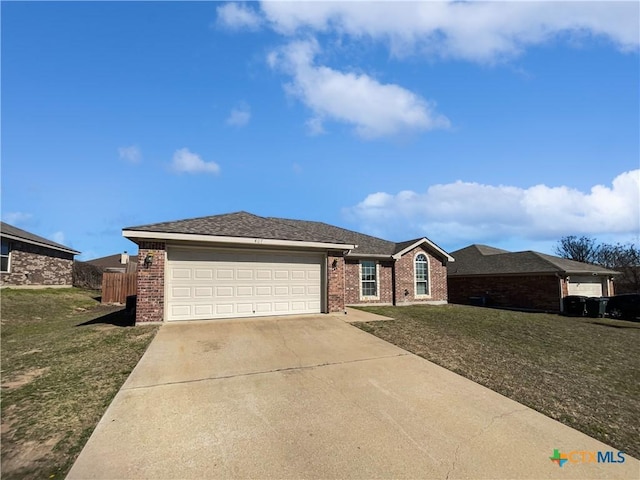 ranch-style home featuring concrete driveway, an attached garage, brick siding, and a front lawn