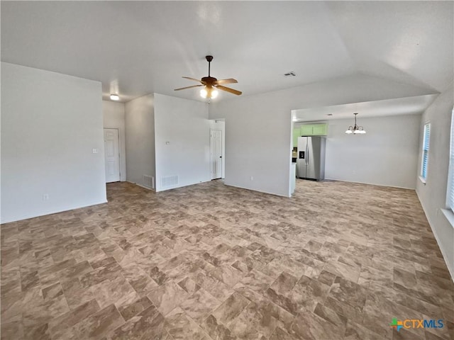 unfurnished living room featuring visible vents, ceiling fan with notable chandelier, and vaulted ceiling