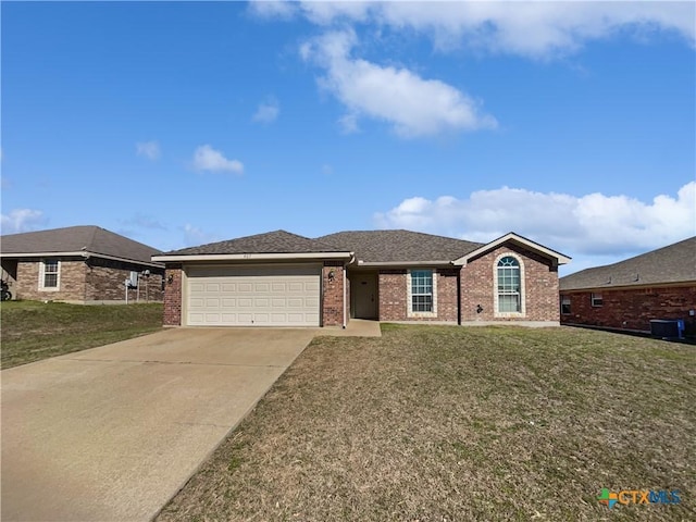 single story home featuring brick siding, a garage, and a front yard