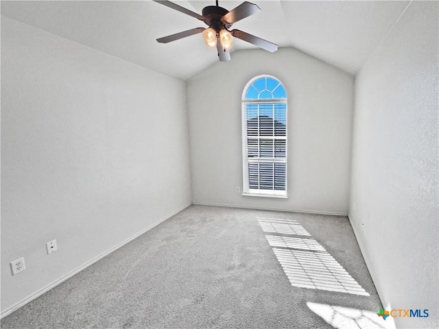 carpeted spare room featuring lofted ceiling, a ceiling fan, and baseboards