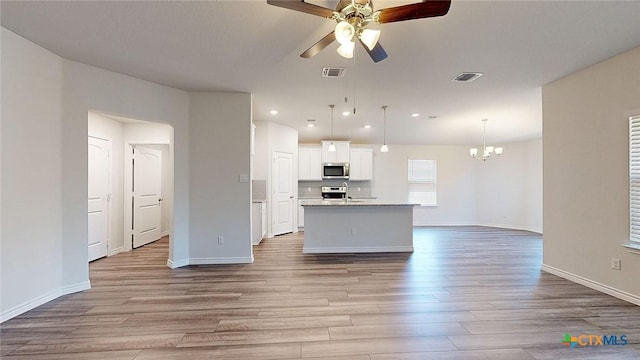 4024 Hayes Ct, Belton, TX 76513 - kitchen featuring stainless steel microwave, a ceiling fan, wood finished floors, range, and white cabinets