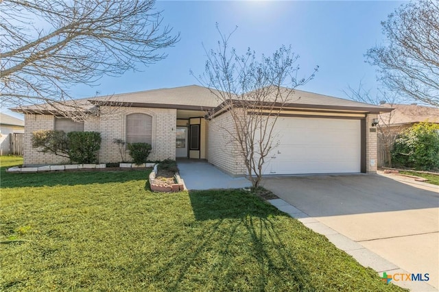 ranch-style house with an attached garage, concrete driveway, brick siding, and a front yard