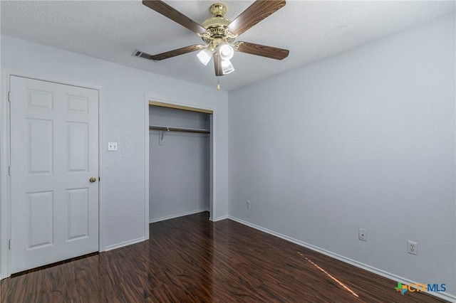 unfurnished bedroom with a closet, a ceiling fan, a textured ceiling, wood finished floors, and baseboards