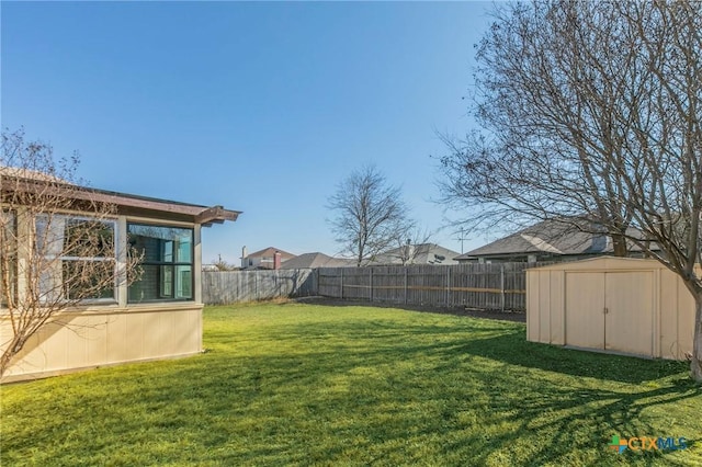 view of yard with an outbuilding, a fenced backyard, and a storage shed