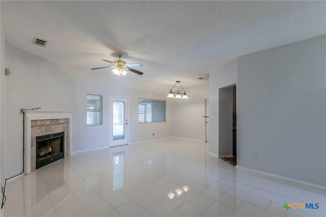 unfurnished living room with baseboards, visible vents, a textured ceiling, a fireplace, and ceiling fan with notable chandelier