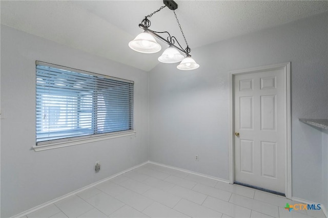 unfurnished dining area with vaulted ceiling, a textured ceiling, and baseboards