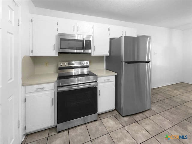 kitchen with white cabinets, stainless steel appliances, and light tile patterned floors