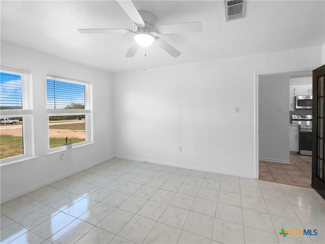 tiled spare room with ceiling fan