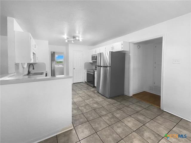 kitchen with stainless steel appliances, white cabinetry, sink, washer / clothes dryer, and tile patterned floors