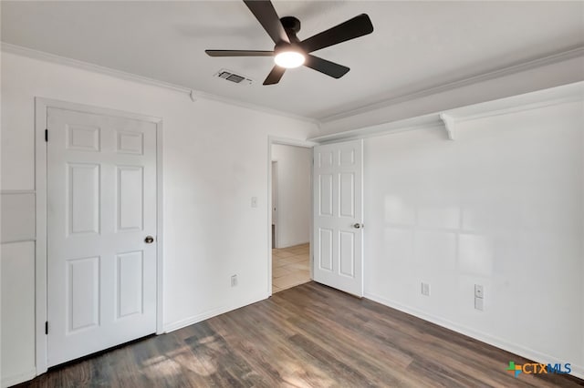 unfurnished bedroom with ceiling fan, dark hardwood / wood-style floors, and ornamental molding