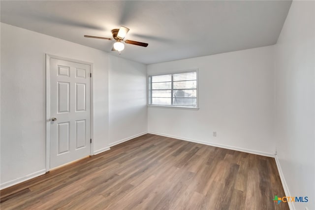 spare room with ceiling fan and dark hardwood / wood-style floors