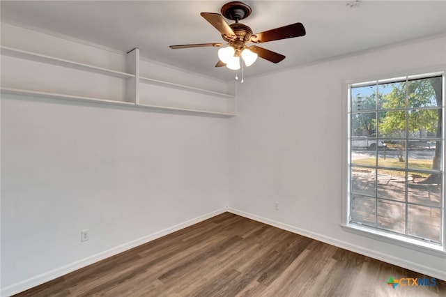 unfurnished room with ornamental molding, dark wood-type flooring, and ceiling fan