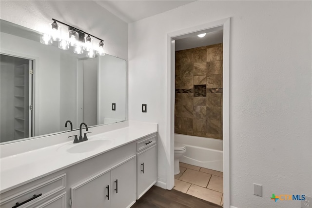 full bathroom with toilet, vanity, tile patterned floors, and tiled shower / bath