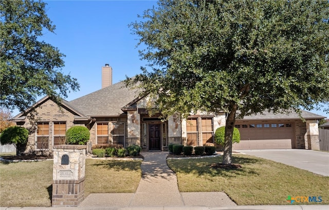 view of front of property with a front yard and a garage