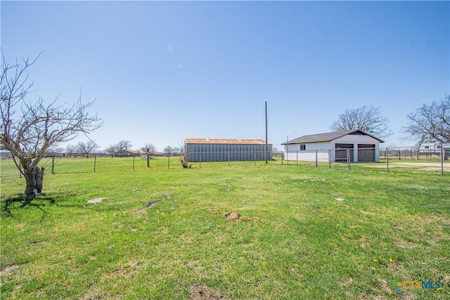 view of yard with an outbuilding, a rural view, and fence