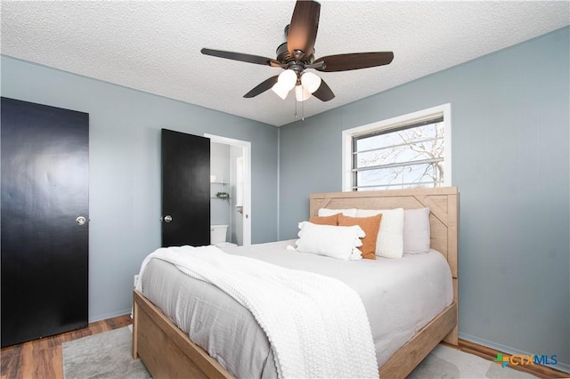 bedroom featuring a textured ceiling, wood finished floors, and a ceiling fan