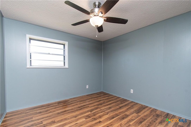 unfurnished room with a textured ceiling and wood finished floors