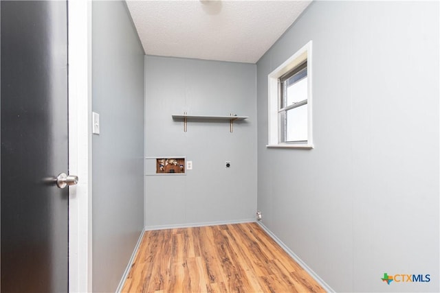 clothes washing area with washer hookup, laundry area, light wood-style floors, electric dryer hookup, and a textured ceiling